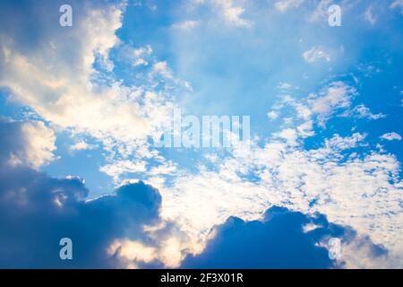 The sun ray behind the clouds in the blue sky. Stock Photo