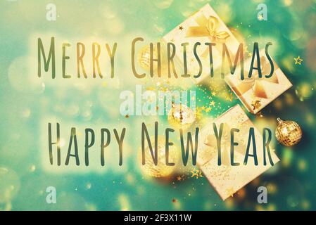 Gift box, shiny gold disco balls, sparkling gold glitter on green background. New year baubles, star sparkles. New year, Christmas, Valentine's day Stock Photo