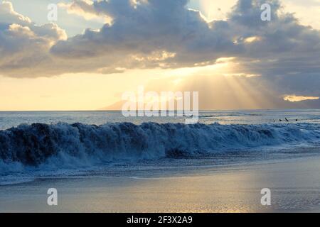 Tahiti, French Polynesia: wave at sunset and Moorea Island in the background Stock Photo