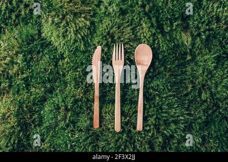 Set of wooden cutlery on green moss background. Sustainable lifestyle. Zero waste, plastic free. Recycling concept. Stock Photo