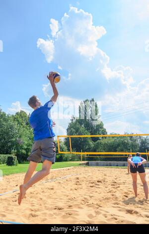 Trendy summer sport - young people playing Beachvolleyball Stock Photo