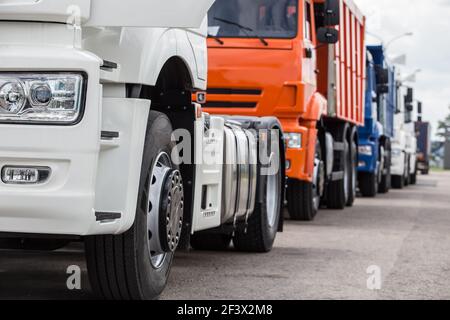 new trucks, dump trucks, semi-trailers in a row for sale. Stock Photo