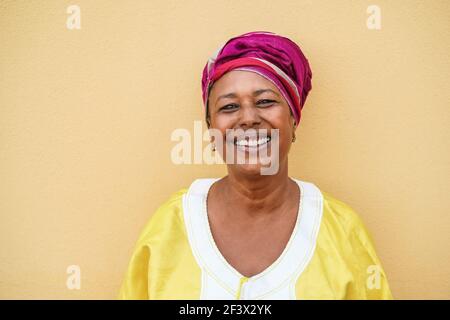 Happy senior african woman wearing traditional dress looking at camera - Focus on face Stock Photo