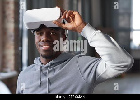 Portrait of African young man in virtual reality glasses on his head smiling at camera Stock Photo