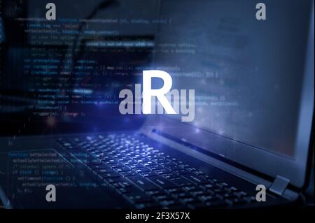 R programming language inscription against laptop and code background. Learn r, computer courses, training. Stock Photo