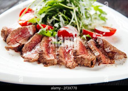Sliced roast beef with greens and tomatoes Stock Photo