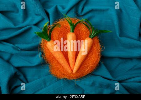 Minimal layout of  bunny carrot orange birds nest against cyan or blue background. Stock Photo