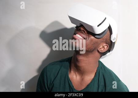 African man wearing 3D glasses trying to play in virtual reality isolated on white background Stock Photo