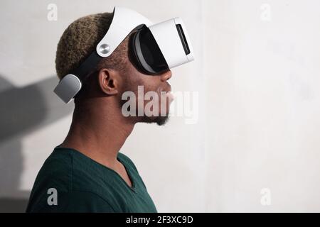 Joyful young man playing computer games with virtual reality goggles isolated on white background Stock Photo
