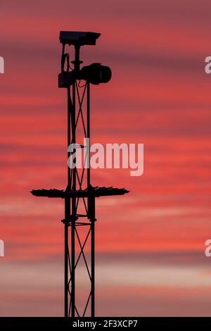 Security camera in silhouette against a pink sky Stock Photo