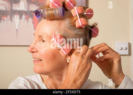 Woman putting her hair in curlers Stock Photo