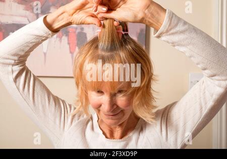 Woman putting her hair in curlers Stock Photo