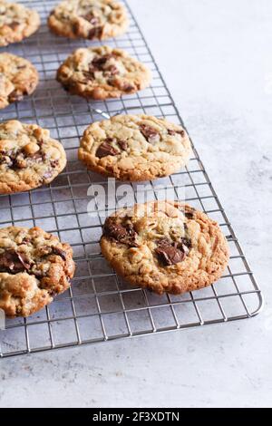 Freshly baked chocolate chip and hazelnut cookies cooling down on a wire rack. Stock Photo