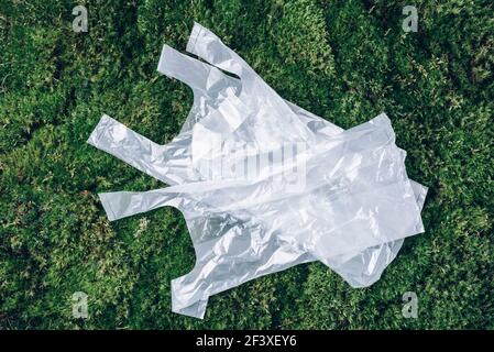 Disposable plastic bags on green moss, grass background. Pollution problem concept. Top view. Copy space. Environmental pollution problem. Garbage Stock Photo