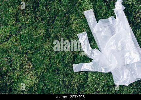 Pollution problem concept. Disposable plastic bags on green moss, grass background. Top view. Copy space. Environmental pollution problem. Garbage Stock Photo