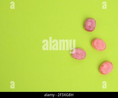 fruit oval lollipops isolated on a green background, copy space Stock Photo