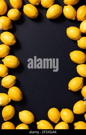 Lemons frame on black background. Immune system booster. Copy space. Top view. Flat lay. Citrus fruits. Vitamins for health. Liposomal vitamin C Stock Photo