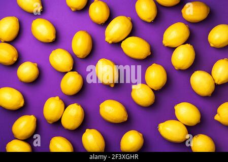 Immune system booster. Fresh lemons pattern on violet background. Copy space. Top view. Flat lay. Citrus fruits. Vitamins for health. Liposomal Stock Photo