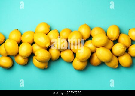 Immune system booster. Fresh lemons pattern on blue background. Copy space. Top view. Flat lay. Citrus fruits. Vitamins for health. Liposomal vitamin Stock Photo