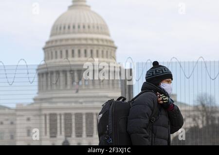 Beijing, USA. 24th Jan, 2021. A man wearing a face mask walks past the U.S. Capitol building in Washington, DC, the United States, Jan. 24, 2021. Credit: Aaron Schwartz/Xinhua/Alamy Live News Stock Photo