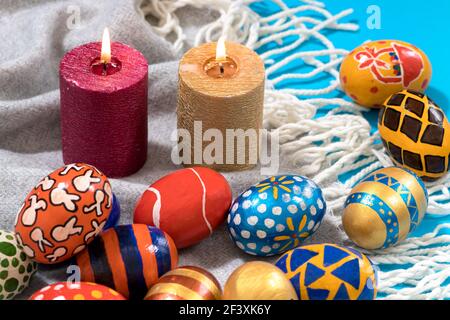 Festive religious photo of the Easter concept on a blue background with candles and painted eggs Stock Photo