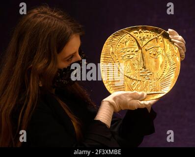 London, UK. 18th Mar, 2021. 'Visage de Faune', a 22 carat Gold plate by Pablo Picasso, estimated £250,000-350,000. The auction of artworks by Pablo Picasso will take place in London on March 23rd. Credit: Mark Thomas/Alamy Live News Stock Photo