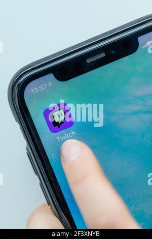 Paris, France - Marsh 18, 2021 : Young woman using the twitch app on her smartphone Stock Photo
