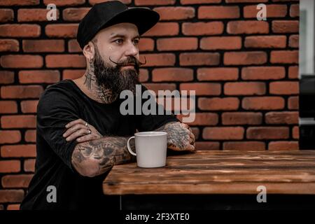 Bearded young male drinking coffee. Hipster man having coffee break. Lifestyle people concept. Stock Photo