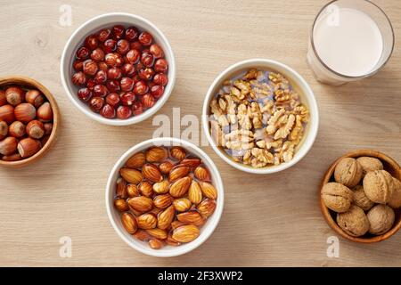 Walnuts, almonds and hazelnuts soaking in water. Soaking organic raw nuts. Stock Photo
