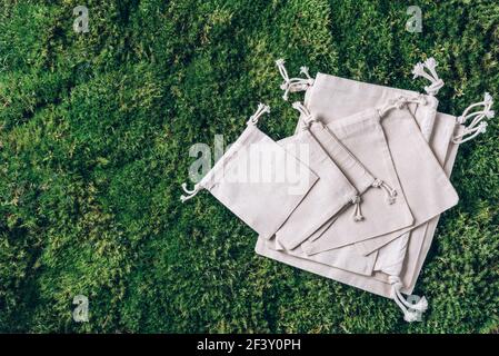 Mesh and cotton bags with on green grass, moss background. Top view. Sustainable ecology lifestyle. Zero waste concept. No plastic. Plastic free Stock Photo