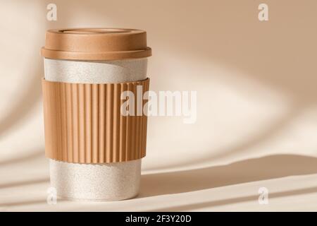 Sustainable bamboo eco friendly cup with silicone holder on natural shadow  beige background. Reusable, biodegradable travel plastic coffee mug for  Stock Photo - Alamy