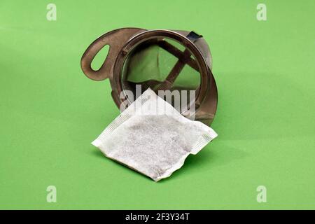 Tea bag packet inside metal strainer ready for infusion in cup Stock Photo