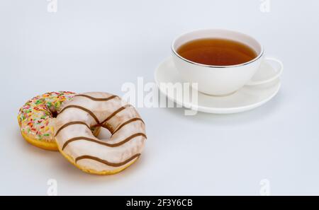 sweet donuts and a cup of tea on a white background. selective focus Stock Photo
