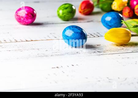 Easter wooden background with coloured eggs. Stock Photo