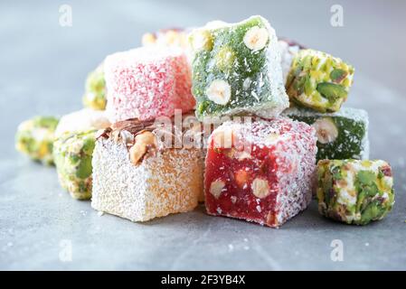 Baklava, halva, rahat lokum, sherbet, nuts, pistachios, in bowl on grey background. Assorted traditional eastern desserts, arabian sweets, turkish Stock Photo