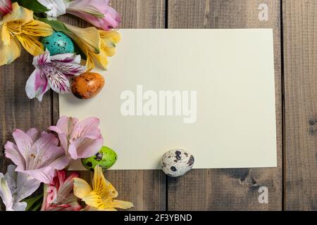 Pink, yellow, magenta, white and red alstroemerias and painted quail eggs and empty card. background from painted eggs and multi-colored flowers on Stock Photo