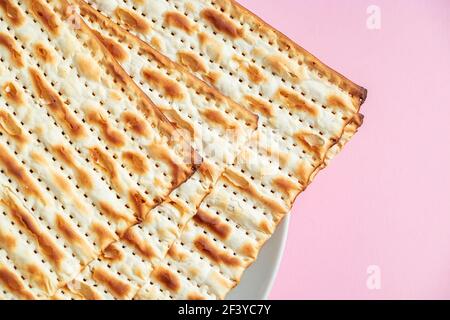 Happy Passover. Matzo on pink background. Traditional Jewish food for regilious spring holiday of Pesach. Stock Photo