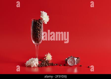 clock wine glass and coffee beans on a red background Stock Photo