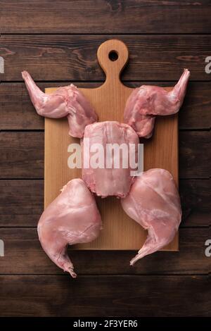 fresh red whole rabbit meat on a wooden cutting board, copy space, vertical photo Stock Photo