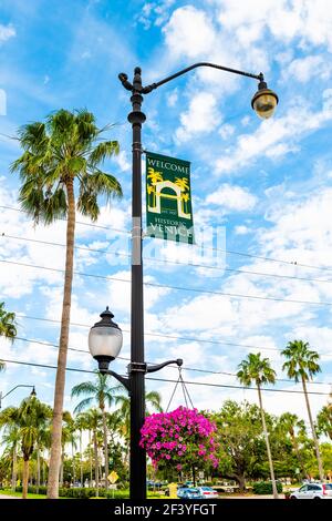 Venice, USA - April 29, 2018: Welcome sign on lamp pole post in small Florida Italian retirement city town in gulf of Mexico with palm trees, hanging Stock Photo