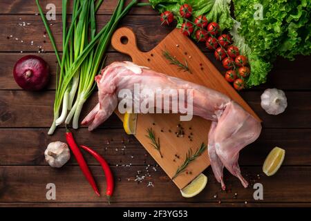 fresh red whole rabbit meat on a wooden cutting board, top view Stock Photo