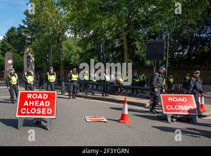 Metropolitan Police officers with road signs, form a line to create a road block to divert a protest demonstration towards another route. Stock Photo