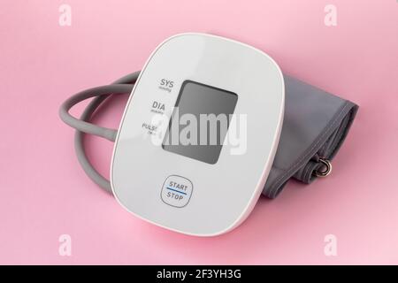 Automatic blood pressure monitor on pink background. Medical electronic tonometer Stock Photo