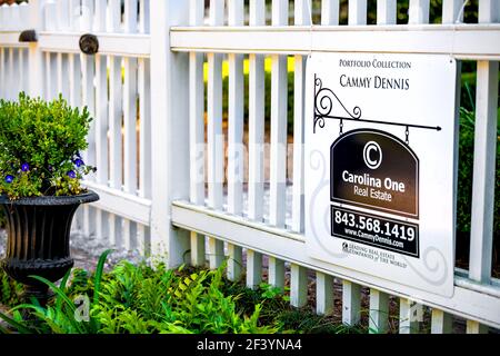 Charleston, USA - May 11, 2018: Mt Pleasant downtown city town with for sale Carolina One real estate sign on white fence Stock Photo
