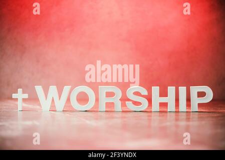 Word Worship made with cement letters on red marble background. Copy space. Biblical, spiritual or christian reminder. Good friday, Easter day in Stock Photo