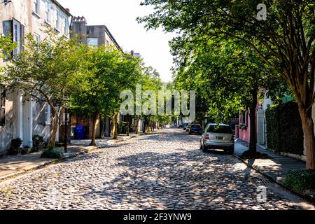Charleston, USA - May 12, 2018: Southern Downtown old town French quarter city cobblestone street, South Carolina with residential apartment homes hou Stock Photo
