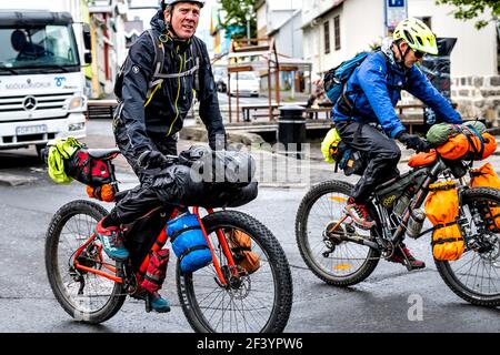 Reykjavik, Iceland - June 19, 2018: Two friends men cyclists riding bicycles fat tire bikes on backpacking tour in Nordic Scandinavian country in summ Stock Photo