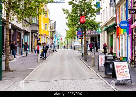 Reykjavik, Iceland - June 19, 2018: Laugavegur shopping street road sidewalk in downtown center and signs for stores shops and tourist guide Stock Photo