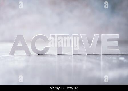 Word ACTIVE made with cement letters on grey marble background. Copy space. Business concept Stock Photo