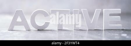 Word ACTIVE made with cement letters on grey marble background. Copy space. Business concept Stock Photo
